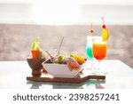 Beachfront dining experience with seafood platter and tropical cocktail. Gourmet cuisine and leisure.