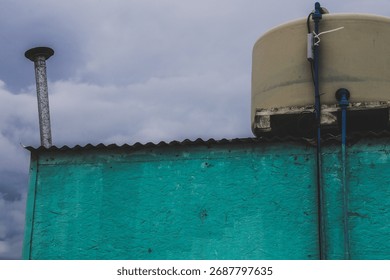 Beachfront location with clouds in the background, water tank, strong colors.
