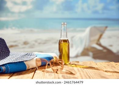 Beachside refreshment. Beer bottle with hat and towel on beach with beautiful ocean view. Concept of summer, vacation, relaxation, travelling, leisure time - Powered by Shutterstock