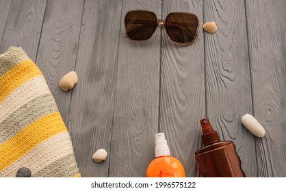 Beachwear Bag Sun Protection Sunglasses Sunscreen Spray Lotion Cream Care Tan Ultra-violet Rays. Summer Background Template Mockup Free Space Pattern Composition Text. Top View Above Wooden Background