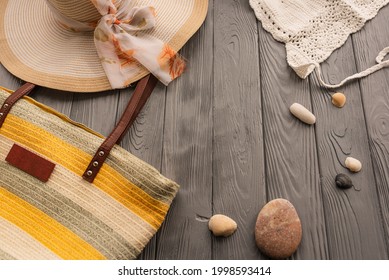 Beachwear Bag Sun Protection Sunglasses. Summer Background Template Mockup Free Space Pattern Composition Text. Sea Pebbles Clothes Outfit Yellow Flat Lay. Top View Above Wooden Background