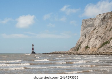 Beachy Head Lighthouse in the English Channel below the white cliffs at low tide, East Sussex, England - Powered by Shutterstock