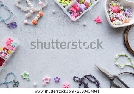 Bead crafting activity shows various colorful beads and tools spread on a gray surface, perfect for creating unique jewelry pieces in the afternoon light.