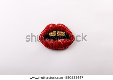 A beaded brooch in the shape of red lips