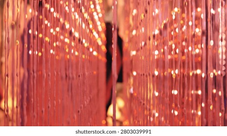 Beads on strings creating a warm, glowing visual texture with out of focus lights