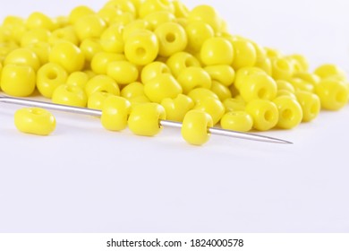 Beads spread on white background with needle. Beads with needle . Close up, macro,It is used in finishing fashion clothes. make bead necklace, beads for woman of fashion,Bead Crochet. Daily Beading.