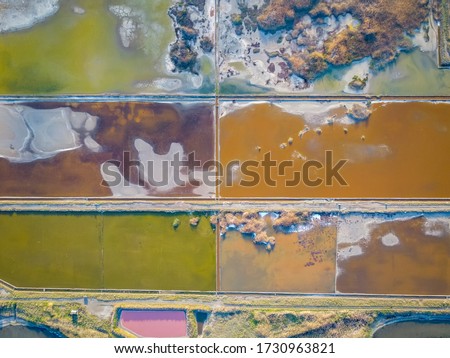 Beaituful aerial sunset view over the Pomorie Salt Ponds in Bulgaria, Black sea coast. Colorful evaporation pools with lye and healing mud on Lake Pomorie - open air SPA