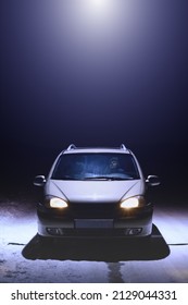 A Beam Of Light Coming From A Ufo Over A Lone Car Parked On The Side Of The Road. A Man Sits In A Car And Looks Up At A UFO. Dark Winter Night. Vertical, Selective Focus