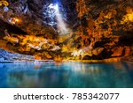 Beam of light shines through an opening in the underground cave onto the thermal hotspring waters at Cave and Basin National Historic Site, the birthplace of Canada