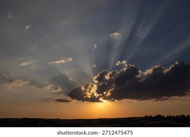 Beam of light through the clouds, sunset, against the silhouette of the modern city