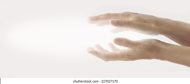 Beaming Reiki Healing Energy  -  Pair Of Female Hands Held Parallel On A Light Background With White Energy Between Palms