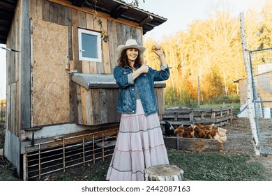 With a beaming smile, a woman displays a perfect queen egg. Happy female farmer rejoices over a fresh egg laid by her chickens in her backyard in the countryside - Powered by Shutterstock