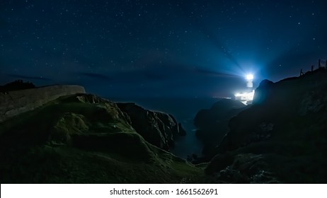 Beams Of Light Shining From Fanad Head Lighthouse At Dark Night With Sky Full Of Stars. Long Exposure Photography. Wild Atlantic Way, Donegal, Ireland