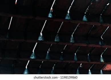 Beams Of Light Shining Through Cracks Between Dark Wooden Floorboards From Underneath