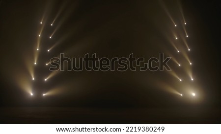 Beams of side spotlights with white soft light illuminating a dark smoky scene. Concert empty stage with spotlights. Theatrical lighting. Points of light shining on a black background in smoke.