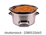 Beans cooking in a stainless crock pot isolated on a white background, cut out.