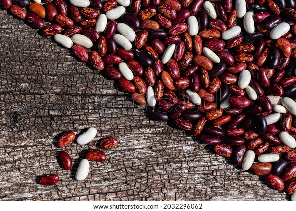 beans lying on a flat wooden surface, dividing it\
in half. High quality\
photo