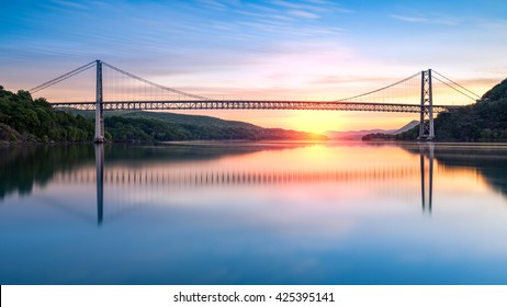 Bear Mountain Bridge at sunrise (long exposure). Bear Mountain Bridge is a toll suspension bridge in New York State, carrying U.S. Highways 202 and 6 across the Hudson River - Powered by Shutterstock