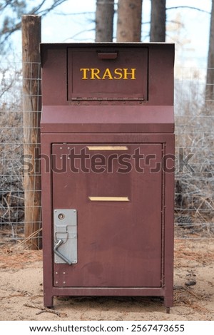 Bear proof trash container at park.  Vertical.