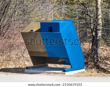 A bear and wildlife proof garbage and recycling disposal box in a forest area