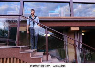 Bearded Arab Man, Businessman Students Gathered To Spend Time At Restaurant And Decided To Have Dinner, Arranged Business Meeting With Colleagues And Waits At Entrance To Restaurant, Smiling And