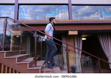 Bearded Arab Man, Businessman Students Gathered To Spend Time At Restaurant And Decided To Have Dinner, Arranged Business Meeting With Colleagues And Waits At Entrance To Restaurant, Smiling And