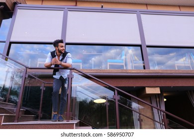 Bearded Arab Man, Businessman Students Gathered To Spend Time At Restaurant And Decided To Have Dinner, Arranged Business Meeting With Colleagues And Waits At Entrance To Restaurant, Smiling And