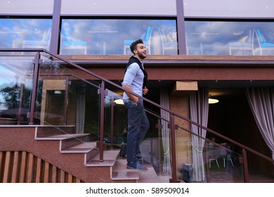 Bearded Arab Man, Businessman Students Gathered To Spend Time At Restaurant And Decided To Have Dinner, Arranged Business Meeting With Colleagues And Waits At Entrance To Restaurant, Smiling And