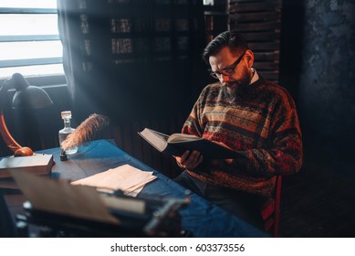 Bearded Author In Glasses Reading A Book