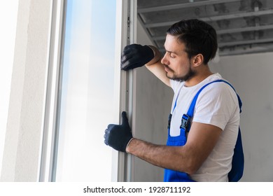 Bearded Builder In Gloves Inspects The Window Frame