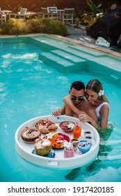 Bearded Caucasian Man Enjoys Asian Food And Swims In Pool With His Beautiful Wife She Hugs Him.