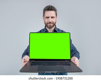 Bearded computer guy hold open laptop with neon green screen for copy space, notebook.