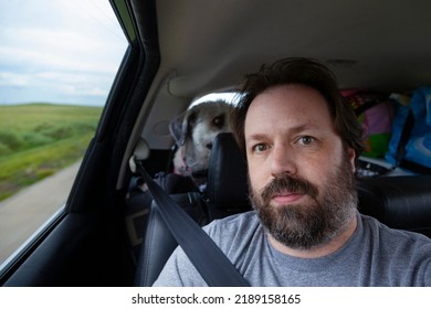 A Bearded Dad Looks Out The Window Of A Car On A Road Trip On Summer Vacation.  Lifestyle Image Of A Candid Moment Of This Middle Aged Man.