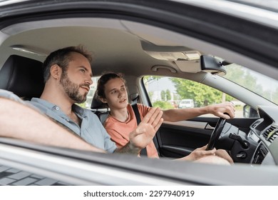 bearded dad pointing while showing direction to teenage son driving car - Powered by Shutterstock