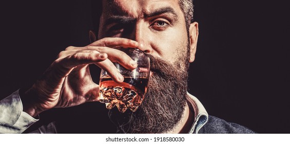 Bearded Drink Cognac. Sommelier Tastes Drink. Man Holding A Glass Of Whisky. Sipping Whiskey. Portrait Of Man With Thick Beard. Macho Drinking. Degustation, Tasting