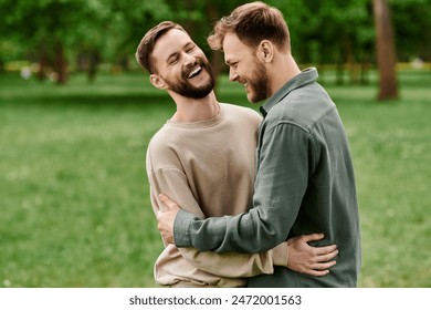 A bearded gay couple shares a moment of laughter and affection while enjoying a sunny day in a green park. - Powered by Shutterstock