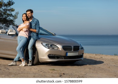 Bearded Guy And Attractive Girl Hugging At The Car, Full Length Shot