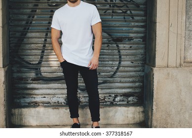 Bearded Guy Wearing White Blank T-shirt And Black Jeans, Standing Opposite Garage 