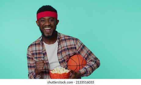 Bearded Happy Young African American Man 20s Sportsman Alone Basketball Fan In Shirt Holding Ball Doing Winner Gesture, Dancing Isolated On Blue Background. Workout Sport Motivation Lifestyle Concept