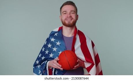 Bearded Happy Young Man 20s Sportsman Basketball Fan In Purple T-shirt Holding American USA Flag Doing Winner Gesture, Dancing Isolated On Gray Background. Workout Sport Motivation Lifestyle Concept