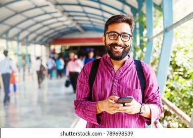 Homem indiano barbudo na estação de metro usando aplicativo em seu smartphone