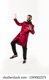 Bearded Indian Man Performing Desi Dance Steps While Wearing Traditional Kurta/sherwani, Celebrating Wedding Or Party, Isolated Over White Background