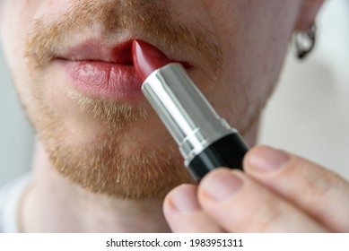 Bearded Man Applying Red Lipstick On His Lips