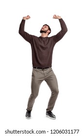 A bearded man in casual clothes attempts to hold something heavy from above on a white background. Heavy object. Lifting something up. Big burden.