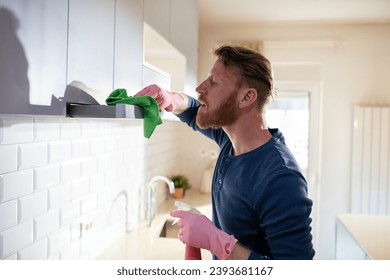 Bearded Man Cleaning the Kitchen Cabinets - Powered by Shutterstock