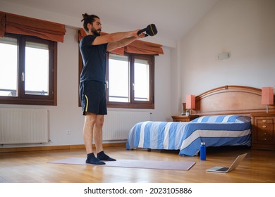 Bearded Man Doing Kettlebell Swing At Home With An Online Exercise Class.