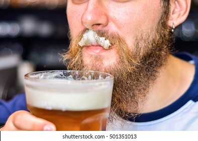 Bearded Man Drinking Beer And Foam On Mustache