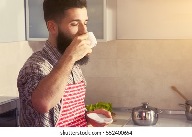 Bearded Man Drinking Cup Of Morning Coffee At Kitchen