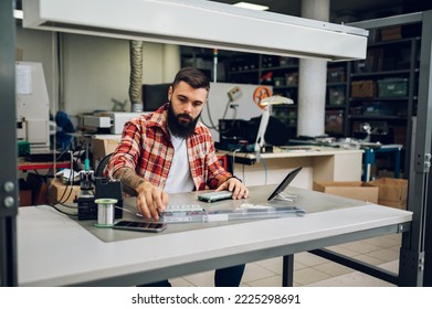 Bearded man electronics technician is disassembling parts of the device he is trying to fix. Computer support engineer. Modern technology. Repairing by hand. Copy space.