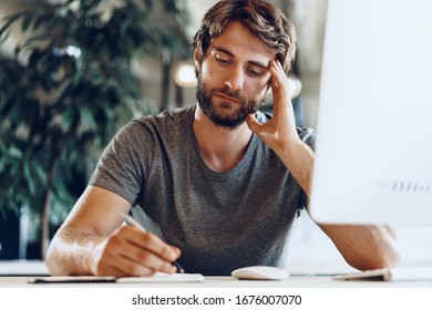 Bearded man freelancer using computer in a modern coworking place. Freelance business concept